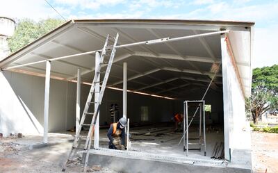 Obreros de la contratista trabajan en la construcción del área para casos respiratorios en el Centro de Salud de Piribebuy.