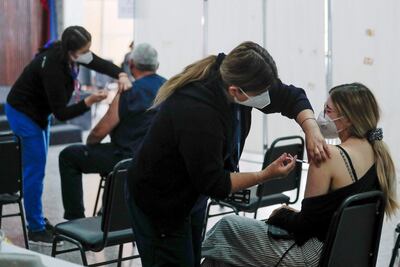 Una mujer recibe una dosis de la vacuna Pfizer, en Santiago de Chile. La tercera dosis de refuerzo de Pfizer protege contra la ómicron, según el labotario.