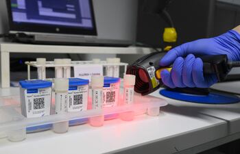 Un personal sanitario escanea los códigos de test rápidos en Alemania. En el Reino Unido una investigación revela que el virus del covid se incubaría más rápido de lo estimado.