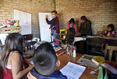 Cira Novara y la voluntaria Camila Brizuela enseñan a los niños del Bañado Sur.