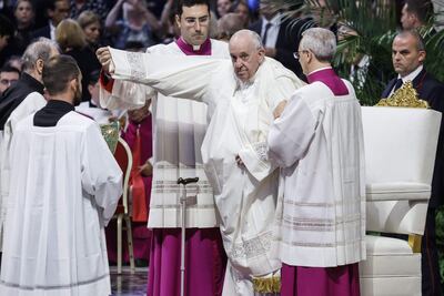 El papa Francisco recibe ayuda con su indumentaria.