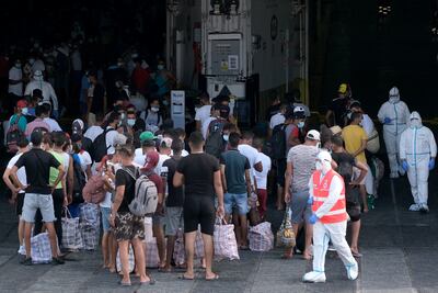 Migrantes abordan el barco de cuarentena 'MS GNV Azzurra' que se envió a la isla italiana Pelagie, de Lampedusa.