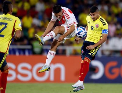El jugador peruano Jeffrey Cabellos disputa la posesión del balón con el colombiano Gustavo Puerta.