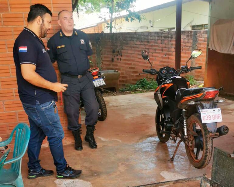Policías de Itapúa junto a la moto de la víctima del atentado.