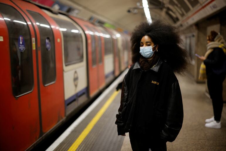 Una mujer con mascarilla en una estación de trenes subterráneos en Londres.