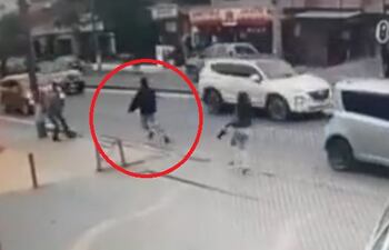 En la imagen se ve al asaltante, dentro del círculo rojo, huyendo de su víctima tras bajarse del bus.