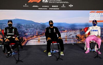 Lewis Hamilton (centro), junto a sus escoltas en la grilla: Valtteri Bottas y Lance Stroll (d).