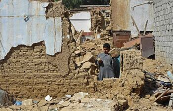 Un niño se encuentra entre los escombros de las casas derrumbadas tras un terremoto en el remoto distrito montañoso de Harnai.