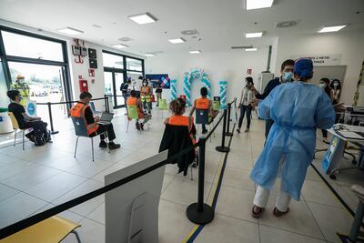 Trabajadores de Amazon esperan recibir su dosis de la vacuna contra el Covid-19 en un centro montado dentro de la sede de la compañía en la sede de Torrazza Piemonte, cerca de Turín, en Italia.