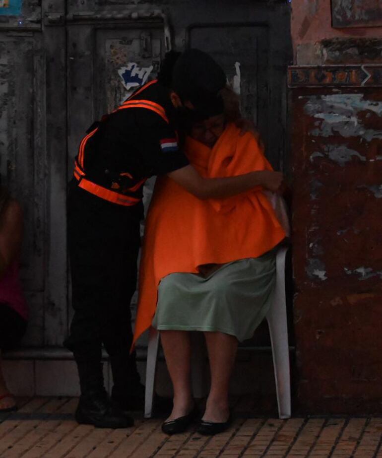 Una mujer es asistida por una agente policial tras ser evacuada del edificio