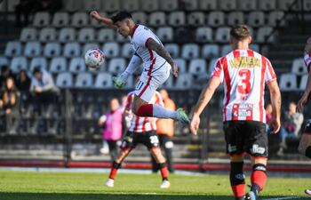 Adam Bareiro salta en procura de controlar el balón en el partido de ayer ante Barracas.