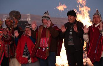 El presidente de Bolivia, Luis Arce (c), junto al expresidente boliviano Evo Morales (2d) participan en la tradición de espera del inicio del Año Nuevo Andino, hoy, en Tiahuanaco (Bolivia). Decenas de bolivianos esperaron toda la noche despiertos en la ciudadela prehispánica de Tiahuanaco para celebrar el Año Nuevo Andino Amazónico y recibir la energía de los primeros rayos del sol del año 5.530, en medio de pedidos de armonía y unidad del país. A pesar de ser una de las noches más frías del año, decenas de personas, especialmente jóvenes, llegaron hasta Tiahuanaco, a unos 80 kilómetros de La Paz, la sede central de los actos de celebración del Año Nuevo Andino Amazónico. (EFE)