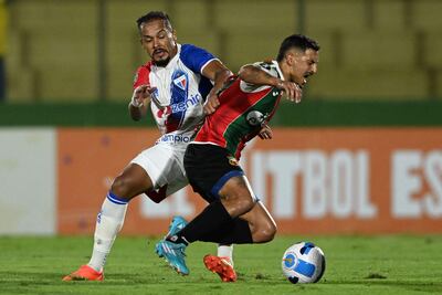 Bruno Pacheco (i), defensor de Fortaleza, lucha por la posesión del balón con Washington Darias, mediocampista del Deportivo Maldonado, durante el partido de ida jugado las emana pasada en Uruguay.
