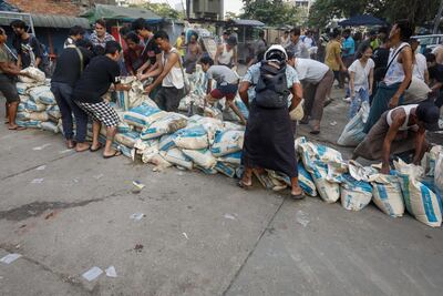 Birmanos levantando barricadas en las calles de la capital de Birmania.