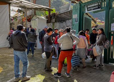 La gente se reúne fuera de la estación de tren de la ciudad de Machu Picchu, Perú para partir después de la llegada del primer tren tras la renovación del servicio de Ollantaytambo el 8 de febrero de 2023. (Ilustración).