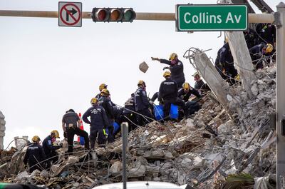 Miembros de los equipos de rescate trabajan entre los escombros del edificio Champlain Towers South en Surfside, Florida.