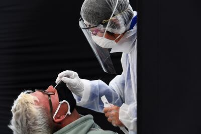 Un trabajador médico toma una muestra de un paciente para una prueba de COVID-19, en Quiberon, Francia.