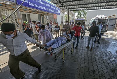 Trabajadores de salud ingresan a un pacientre con Covid-19 a un hospital en Ahmedabad, India.