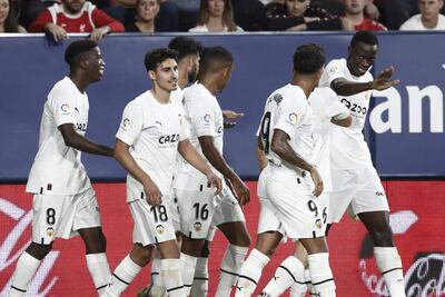 Los jugadores del Valencia celebran el gol de Mouctar Diakhaby (d) ante el Osasuna, durante el encuentro correspondiente a la octava jornada de primera división que hoy viernes en el estadio de El Sadar, en Pamplona.