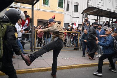 Supporters of Peruvian President Pedro Castillo clash with the police to reach the Lima Prefecture, where Castillo is alleged to be, in Lima, on December 7, 2022. - Peru's President Pedro Castillo dissolved Congress on December 7, 2022, announced a curfew and said he will form an emergency government that will rule by decree, just hours before the legislature was due to debate a motion of impeachment against him. (Photo by ERNESTO BENAVIDES / AFP)