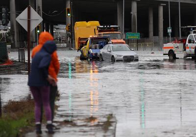Una grúa estira un auto en una intersección inundada en Mill Valley, California.