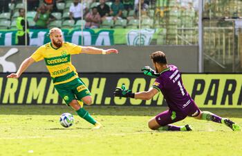 Isidro Pitta intenta eludir la salida de Matheus Fernando Cavichioli, arquero del América Mineiro, quien tocó el balón con la mano fuera del área y fue expulsado. Del tiro libre, Cuiabá marcó el gol de la victoria.