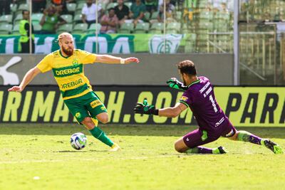 Isidro Pitta intenta eludir la salida de Matheus Fernando Cavichioli, arquero del América Mineiro, quien tocó el balón con la mano fuera del área y fue expulsado. Del tiro libre, Cuiabá marcó el gol de la victoria.
