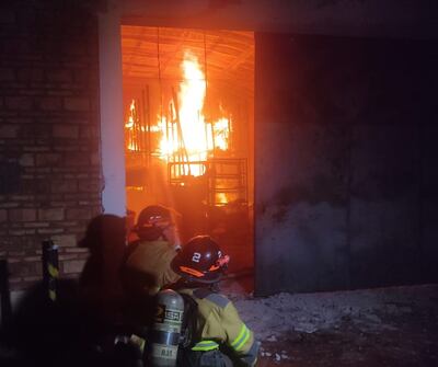 Bomberos trabajan arduamente para aplacar el incendio.