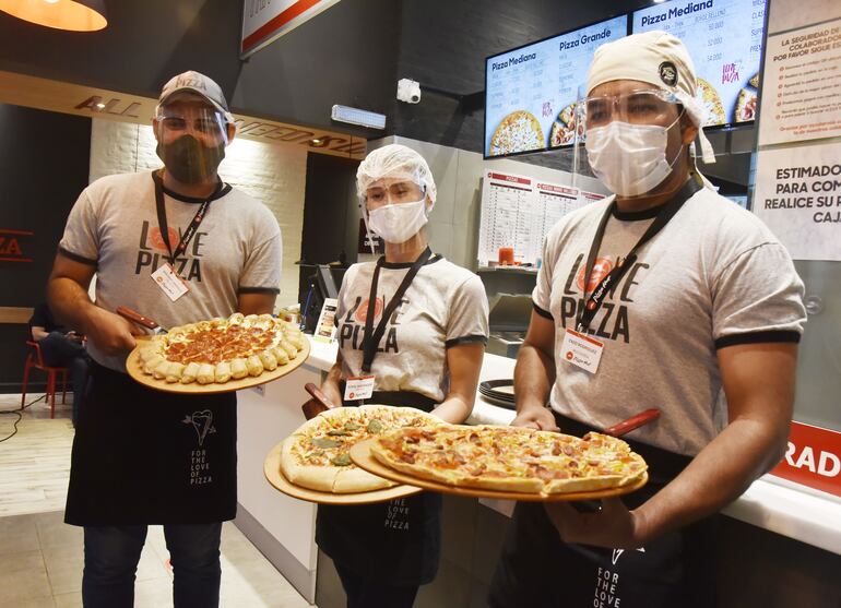 Variedad de pizzas es preparada en el local.