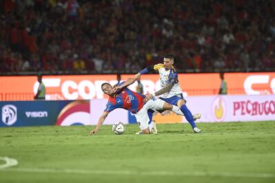 Dura puja por el balón entre Robert Piris da Motta(28) y Jorge Mendoza (33).