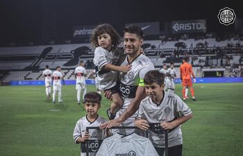 Iván Torres posa feliz y emocionado con sus hijos Elías, Emmanuel y Piero, tras ser homenajeado por sus 200 partidos con la casaca del Olimpia.