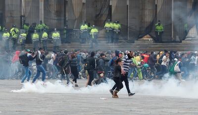 Miembros de las fuerzas del orden dispersan con gases a manifestantes durante un cacerolazo este viernes, en la Plaza Bolívar de Bogotá (Colombia).