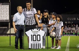 Rubén Di Tore entrega a Óscar Cardozo la camiseta enmarcada en alusión al “centenar de goles”.