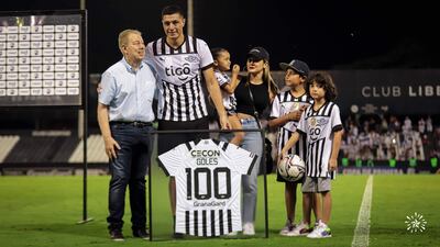 Rubén Di Tore entrega a Óscar Cardozo la camiseta enmarcada en alusión al “centenar de goles”.