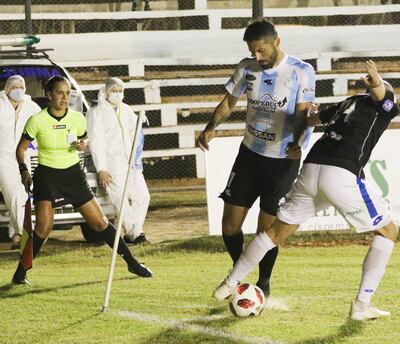 El goleador histórico Salcedo, quien ayer anotó un gol, ante la marca Menéndez, y observa la asistente Nancy Fernández.