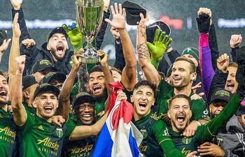 Cristhian Paredes, con la bandera paraguaya en mano, festeja con sus compañeros del Portland Timbers el título de la Conferencia Oeste de la MLS.
