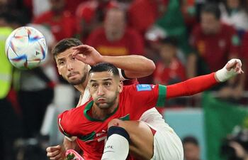 El marroquí Hakim Ziyech cubre la posesión del balón ante el portugués Ruben Dias.