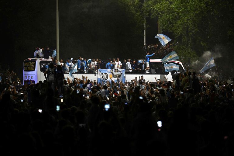 Los jugadores de la selección de Argentina a bordo del bus descapotable durante el recorrido hasta el predio de Ezeiza en compañía de miles y miles de argentinos, que recibieron al plantel en el Aeropuerto Internacional de Ezeiza después de la conquista del Mundial Qatar 2022. 