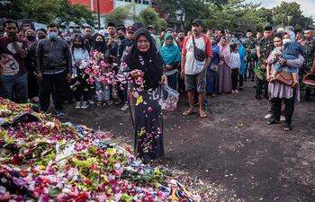 Una mujer llora mientras presenta sus respetos por las víctimas de la estampida en el estadio Kanjuruhan en Malang, Java Oriental el 4 de octubre de 2022.