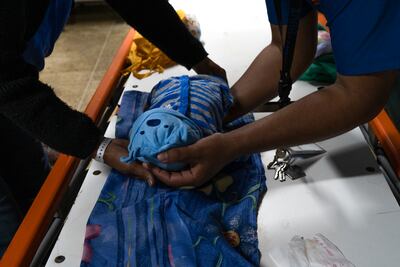 Wendy Dulcey (izq.) y su esposo preparan el cuerpo de su hijo de un mes que falleció en la sala de cuidados intensivos del Hospital Universitario de Caracas el 10 de enero de 2021. La mortalidad infantil en Venezuela aumentó un 30,12% en 2016, con 11.466 muertes de niños de 0 a 1 año, y la mortalidad materna se disparó 65%, según las últimas cifras publicadas por el Ministerio de Salud.