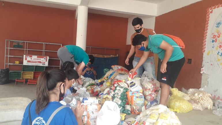 Jóvenes colaborando con bomberos y pobladores en la zona de Cateura.