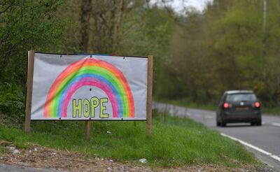 Un coche pasa junto a un cartel de un arcoiris dibujado a mano con la palabra "Hope" (esperanza), en Lamberhurst, al sureste de Inglaterra.