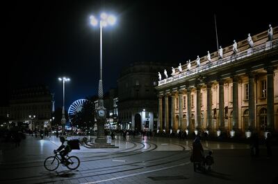Un repartidor de comida anda en bicicleta frente al Gran Teatro de Burdeos, suroeste de Francia, el 29 de octubre de 2020, antes de un nuevo cierre nacional en Francia destinado a frenar la propagación de la pandemia.