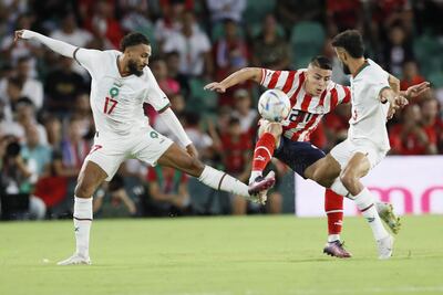 El extremo marroquí Sofiane Boufal (i) lucha con el centrocampista paraguayo Braian Ojeda (c) durante el partido amistoso entre las selecciones de Marruecos y Paraguay disputado en el estadio Benito Villamarín de Sevilla, este martes.