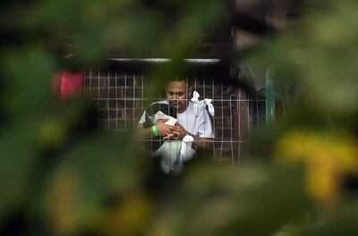 Un migrante mira a través de la valla en el centro de acogida de inmigrantes de corta estancia de Manston, Reino Unido.