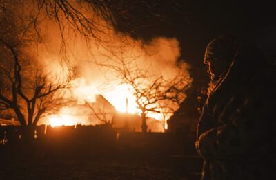 Una mujer observa un edificio en llamas luego de un bombardeo ruso en una localidad cerca de Bajmut, en la región ucraniana de Donetsk.