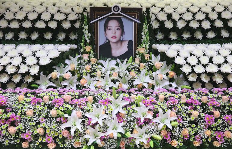 El retrato de la K-pop star Goo Ha-ra se ve rodeado de flores en el memorial.