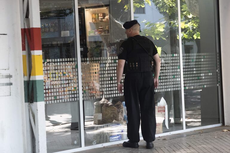 Un agente policial resguarda hoy el supermercado de la familia de Antonela Roccuzzo, que fue atacado a tiros por dos personas cerca de las 3 de la madrugada, en Rosario (Argentina).