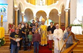 El obispo Pedro Collar y el sacerdote Gianluiggi Arofo, posan junto a los integrantes del coro de la basílica Nuestra Señora del Pilar, luego de la celebración de la Santa Misa.