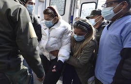 La expresidenta interina de Bolivia, Jeanine Áñez, camina hoy acompañada por sus hijos José Armando Ribera (i) y Carolina Ribera (3-d) hacia un centro médico para realizarse unos exámenes, en La Paz (Bolivia). La expresidenta transitoria de Bolivia Jeanine Áñez manifestó este martes que ya "no quiere vivir", dos días después de haberse generado lesiones en los brazos y en una jornada en que la administración penitenciaria la sacó del penal en que está recluida para hacerle nuevas pruebas médicas.